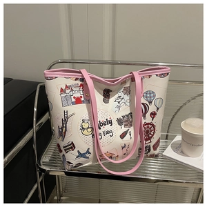 Detalle del bolso tote estampado con ilustraciones de viaje coloridas y asas rosas