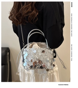 Detail of silver sequined bucket bag featuring drawstring satin liner and chain strap