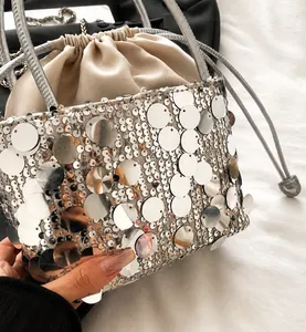 Detail showing shiny silver sequins and drawstring closure on a chic bucket bag
