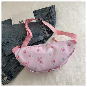 Detalle de riñonera rosa con estampado de rosas y correa de nailon ajustable