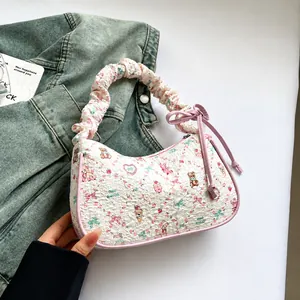 Close-up of cream textured bag featuring cute bear prints and pink contrast piping detail
