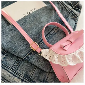 Primer plano del bolso rosa mini con encaje y detalle de la hebilla metálica de ajuste