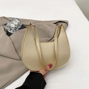 Golden textured leather crescent bag with top handle and zip closure in a minimal style