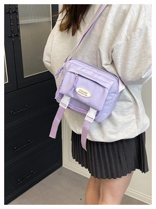 Light purple nylon crossbody bag with fashion logo and adjustable strap on model