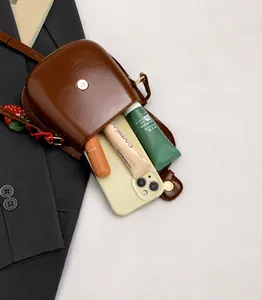 Innenansicht einer braunen Satteltasche mit viel Platz für Handy und Make-up-Zubehör