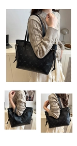 Close-up of black lychee grain leather tote bag with pattern and hardware details