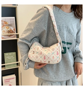 Detailed close-up of quilted white underarm bag with cute cartoon bear and rabbit prints