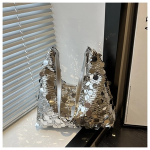 Détail d'un sac hobo à paillettes argentées avec reflets métalliques et bandoulière