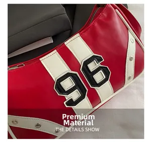 Close-up of premium red leather handbag featuring white 96 patch and silver metal rivets