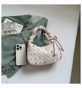 Close-up of white bubble fabric handbag with cartoon bear print and pink bow details