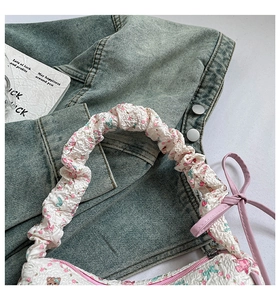 Detail of floral bear print bag with textured bubble fabric and pink ribbon decor