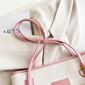 Dettaglio della comoda tracolla in ecopelle su una borsa tote rosa chiaro
