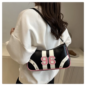 Detail of retro black leather underarm bag with pink piping and 96 number patch