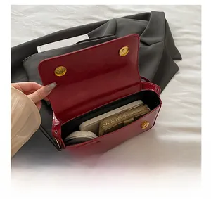 Detailed interior view of red patent leather shoulder bag showing spacious storage capacity