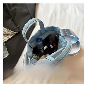 Detail showing the spacious interior of the light blue crossbody bag with cosmetics