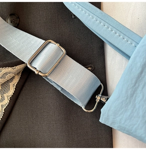 Détail de la bandoulière tissée bleu clair avec boucle et accessoires en métal argenté