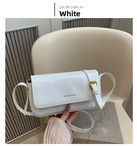 Detail of white glossy leather crossbody bag with golden buckle and KEKEDOU brand logo
