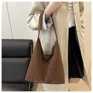 Vista laterale della borsa tote grande con stampa leopardata e finitura in finto camoscio