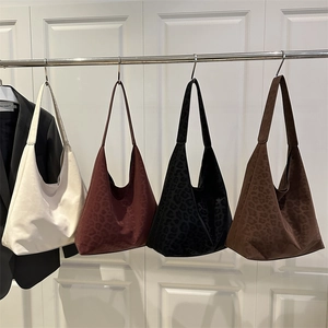 Grands sacs cabas rétro à imprimé léopard en plusieurs couleurs dans un studio minimaliste