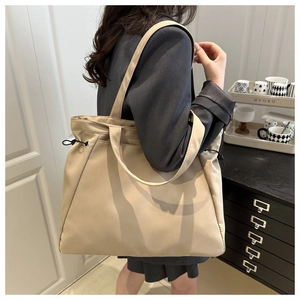 Dettaglio della borsa tote grande in nylon beige con coulisse laterale e doppi spallacci