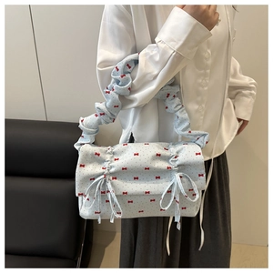Detail of light blue bow handbag with bubble strap and red polka dot patterns