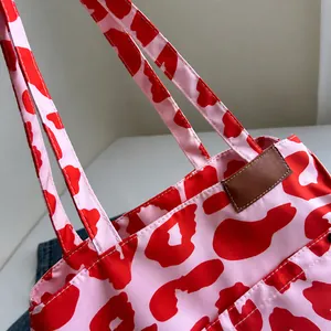 Detailaufnahme der roten Tote-Bag mit Leopardenmuster, braunem Lederbesatz und feiner Steppnaht