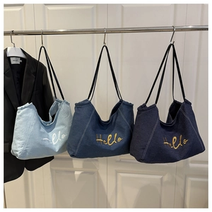 Detail van het Hello borduursel op deze grote denim draagtas met zwarte handvaten