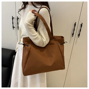 Dettaglio della coulisse laterale regolabile su una borsa tote marrone di grande capacità