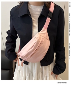 Gros plan du sac bandoulière rose clair en nylon imperméable avec sangle réglable et zips