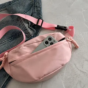 Detail van de roze nylon heuptas met voorvak met rits voor het opbergen van een mobiel