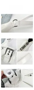 Close-up of silver buckles, precision stitching and magnetic clasp on white pleated bag