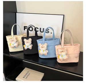 Detail view of mini canvas tote bags in four colors with cute plush bear charms