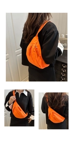 Detail of bright orange waterproof nylon crossbody bag showing adjustable straps and zippers