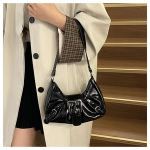 Détail d'un sac à bandoulière en cuir verni noir brillant avec boucle argentée de style vintage