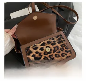 Detail view of leopard print crossbody bag featuring premium gold magnetic hardware buckle