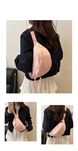 Detailed macro view of pink nylon crossbody bag showing the zipper and adjustable strap