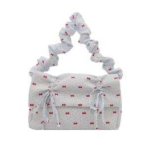 Light blue ruched handbag with red bow print and drawstring ruffles in a floral style