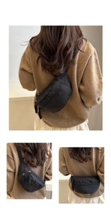 Detailed view of black nylon waist bag featuring dual zippers and adjustable webbing strap