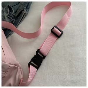 Detail of pink nylon shoulder strap with durable black plastic quick release buckle and slider