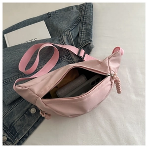 Detail of pink nylon crossbody bag interior showing spacious storage for phone and wallet