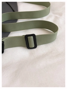 Gros plan sur la bandoulière en nylon vert militaire avec boucle réglable en plastique