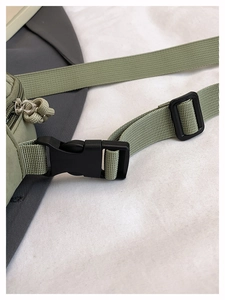 Détail de la boucle noire et de la sangle en nylon du sac de sport vert sauge
