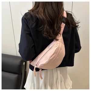 Détail du sac banane en nylon rose avec boucle et sangle tissée ajustable