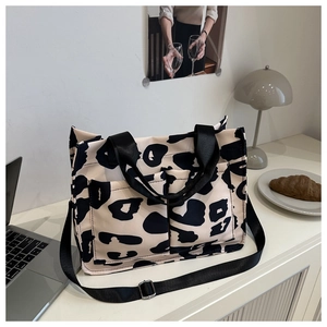 Dettaglio macro della borsa tote in tela leopardata, doppie tasche e tracolla