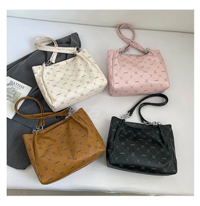 Vue à plat de sacs cabas en cuir texturé en quatre couleurs avec imprimé ours et déco