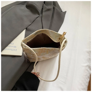 Draufsicht der Jacquard-Beuteltasche mit Goldreißverschluss, Quaste und braunem Futter