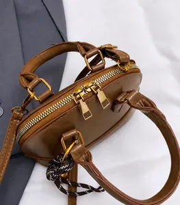 Detail of vintage brown mini boston bag featuring gold double zipper and leather handle