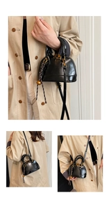Detail of a mini shell bag in black patent leather with golden hardware and bell charm