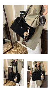 Λεπτομέρεια vintage μαύρης ματ τσάντας tote με διακοσμητική τσέπη και λούτρινο κρεμαστό