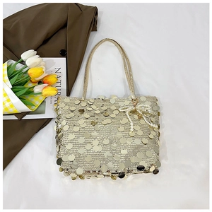 Detail of golden sequin tote bag featuring premium texture and pearl bow charm